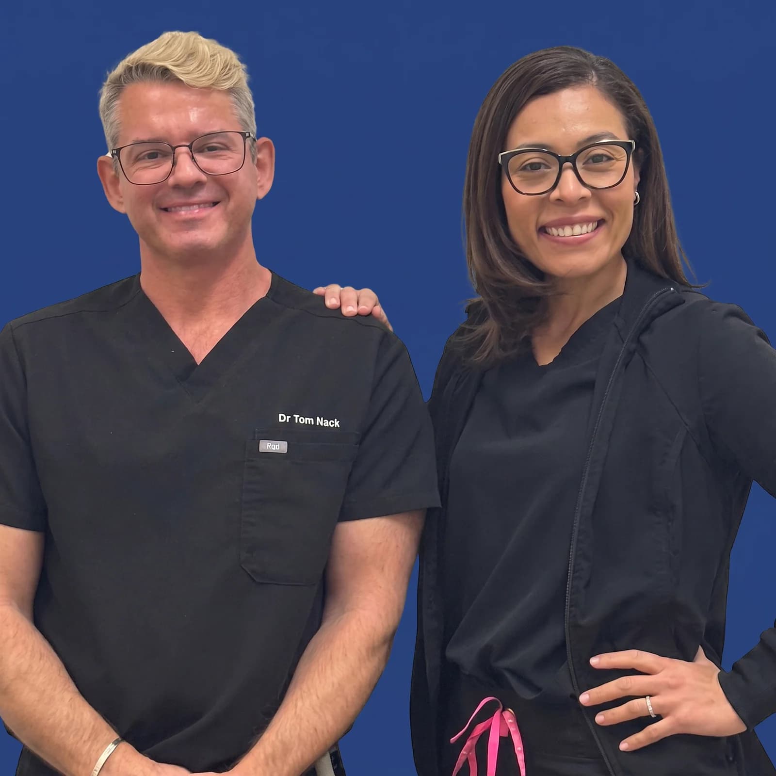 Dr. Tom Nack standing with a smiling Mountain View Smiles team member against a blue background